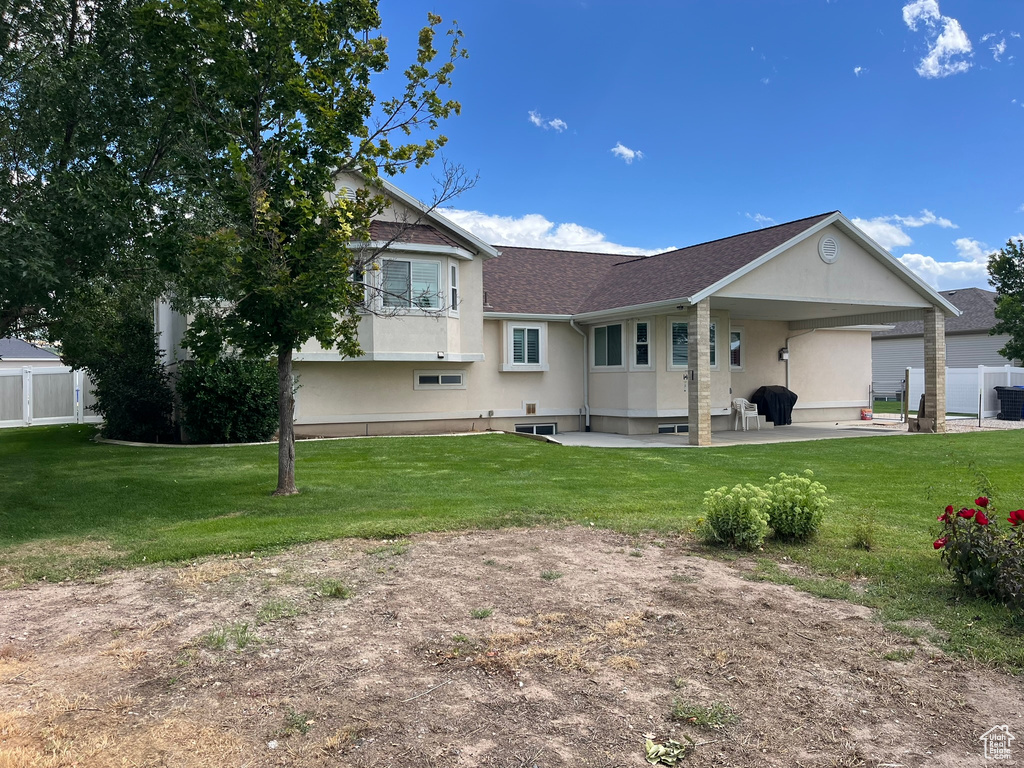 View of front of home featuring central AC unit, a front yard, and a patio