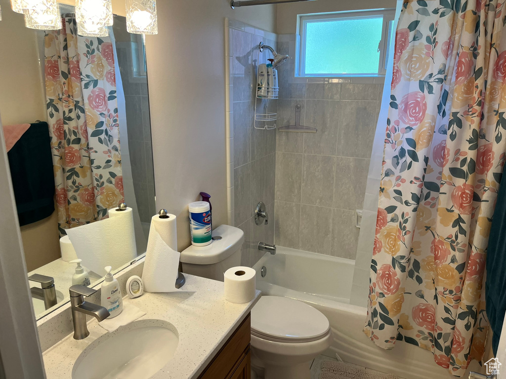 Full bathroom featuring toilet, vanity, and shower / bath combo with shower curtain