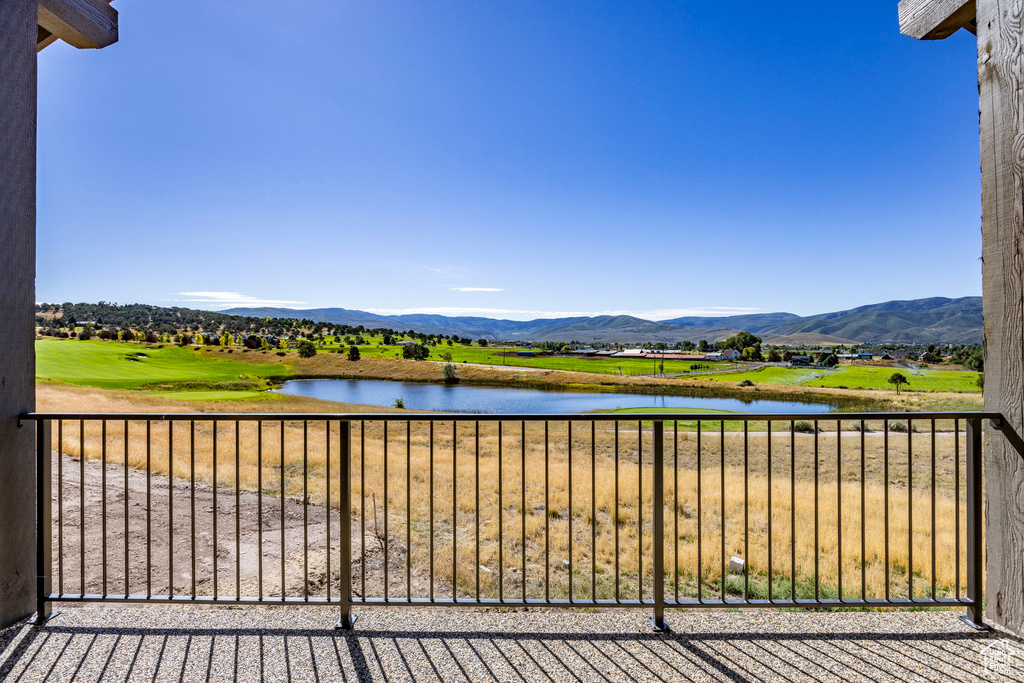 Balcony featuring a water and mountain view