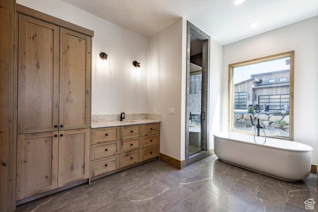 Bathroom with tile patterned flooring, vanity, and shower with separate bathtub