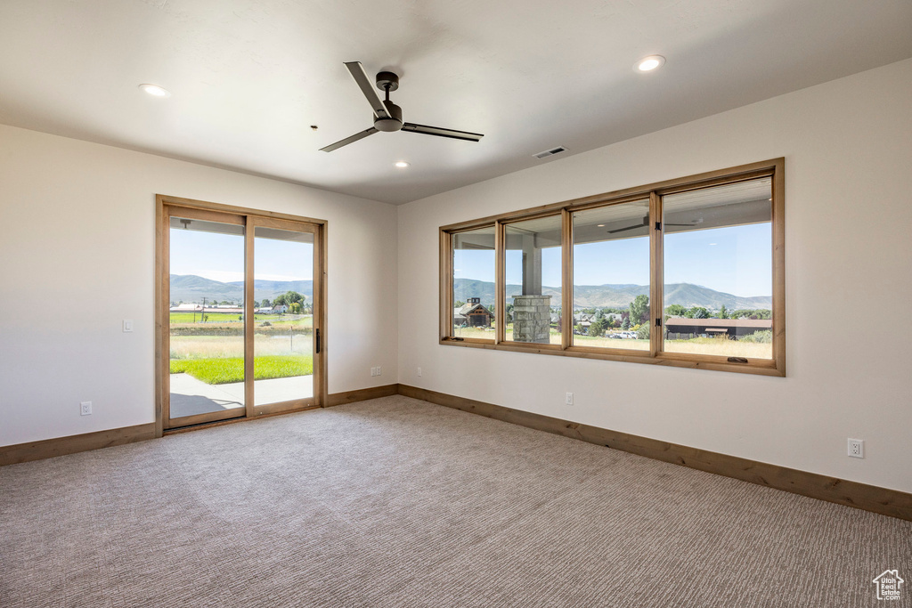 Unfurnished room featuring plenty of natural light, carpet floors, and a mountain view