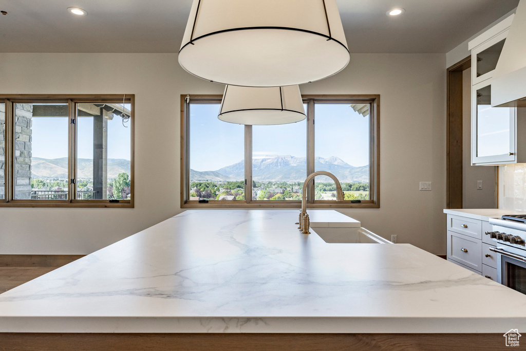 Kitchen with a mountain view, sink, and a center island with sink