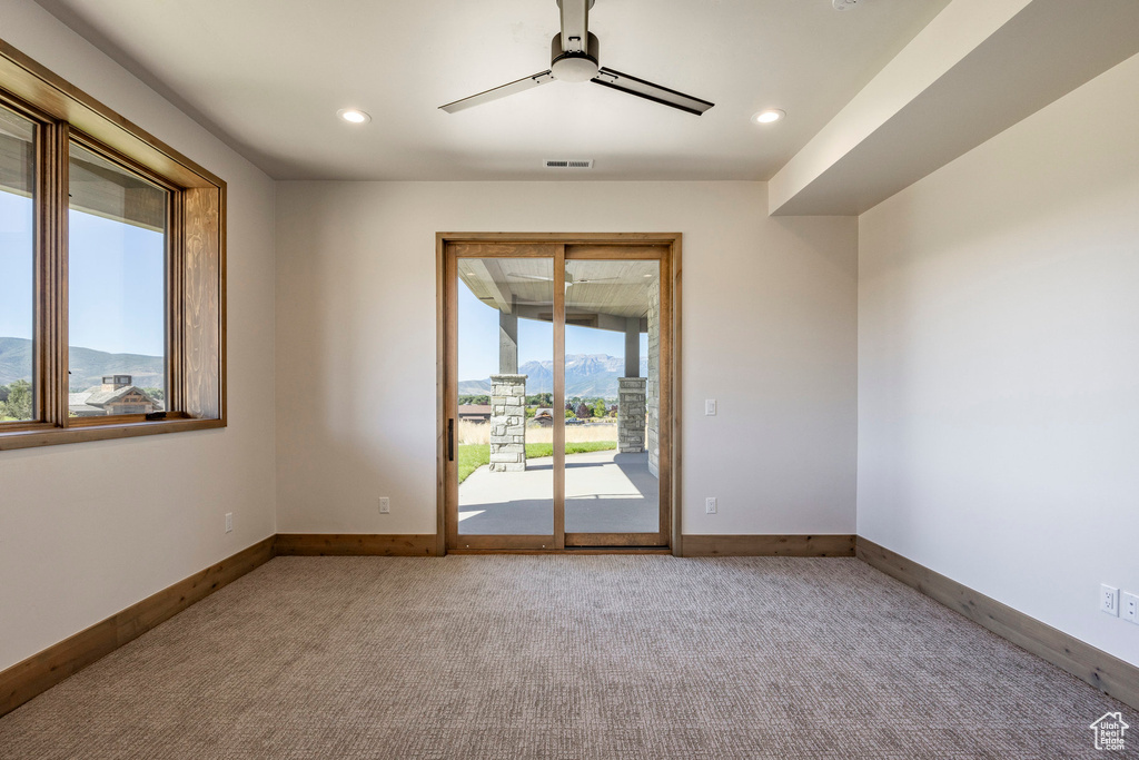 Carpeted spare room featuring ceiling fan and a mountain view