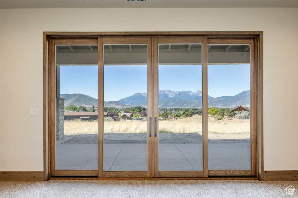 Entryway with light colored carpet and a mountain view