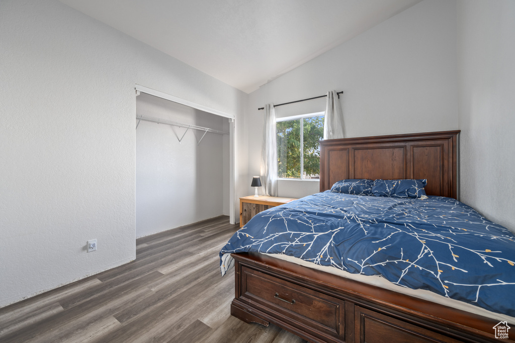 Bedroom with a closet, lofted ceiling, and hardwood / wood-style floors