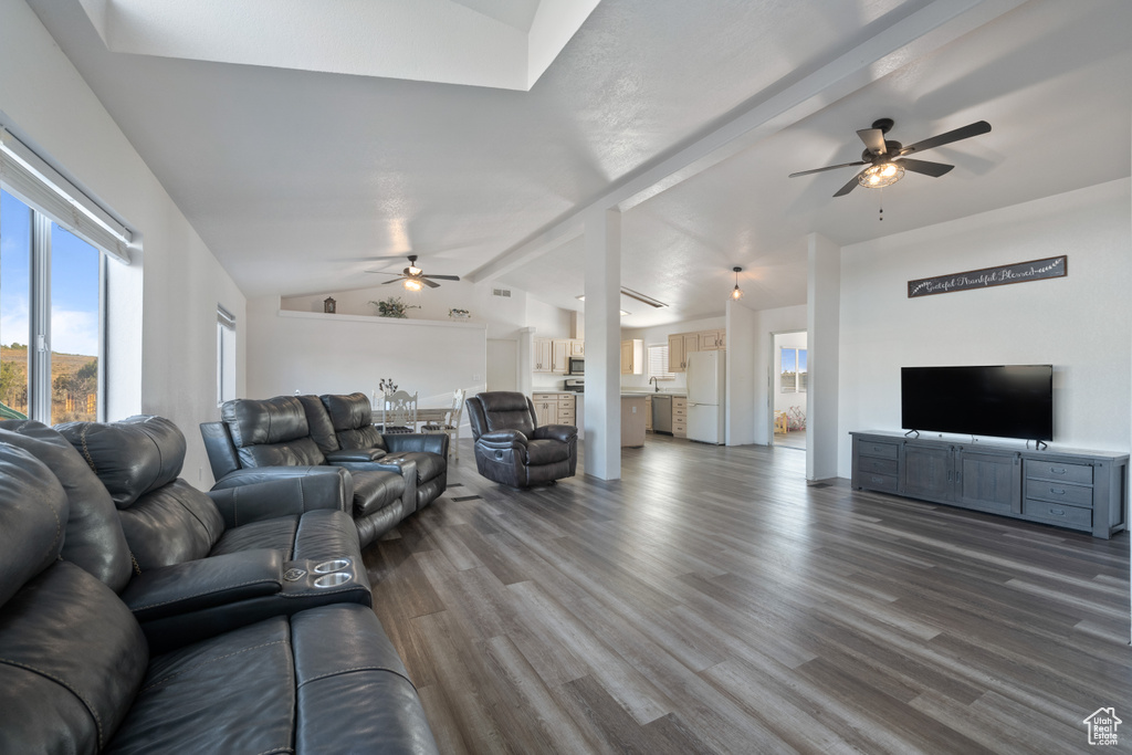 Living room featuring ceiling fan, vaulted ceiling with beams, and hardwood / wood-style flooring