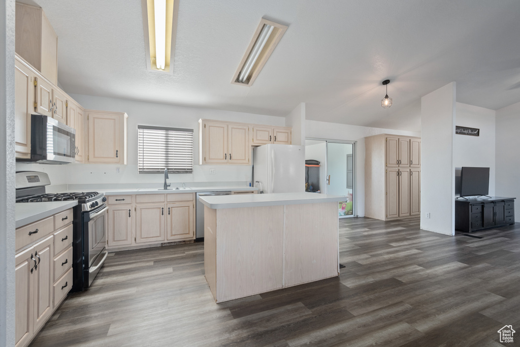 Kitchen with sink, appliances with stainless steel finishes, hardwood / wood-style flooring, light brown cabinetry, and a kitchen island