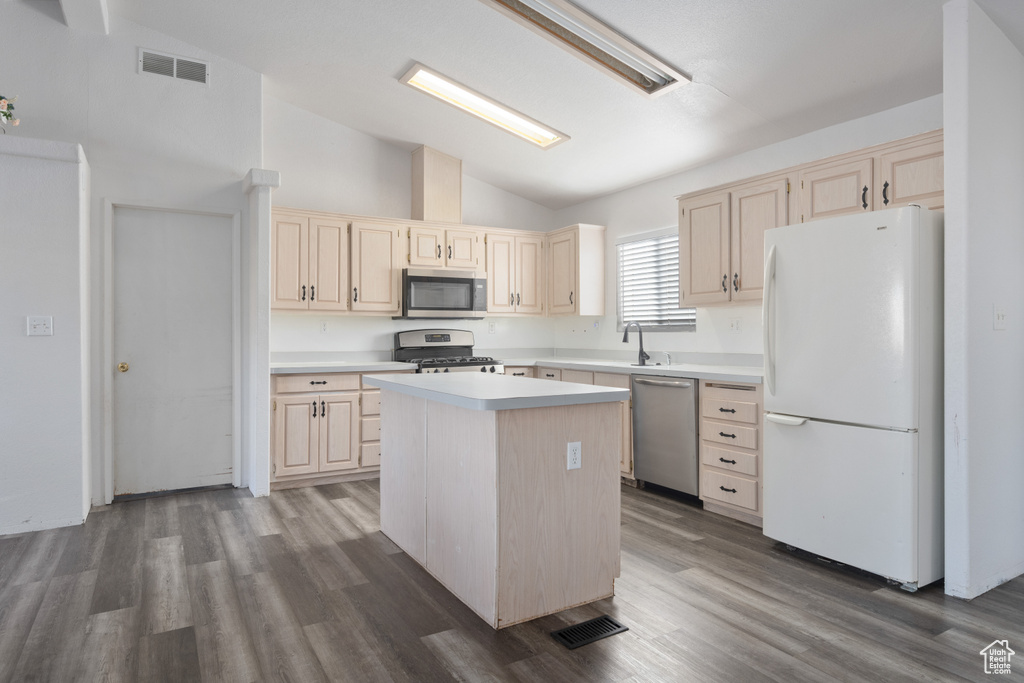 Kitchen featuring appliances with stainless steel finishes, a center island, high vaulted ceiling, and hardwood / wood-style floors