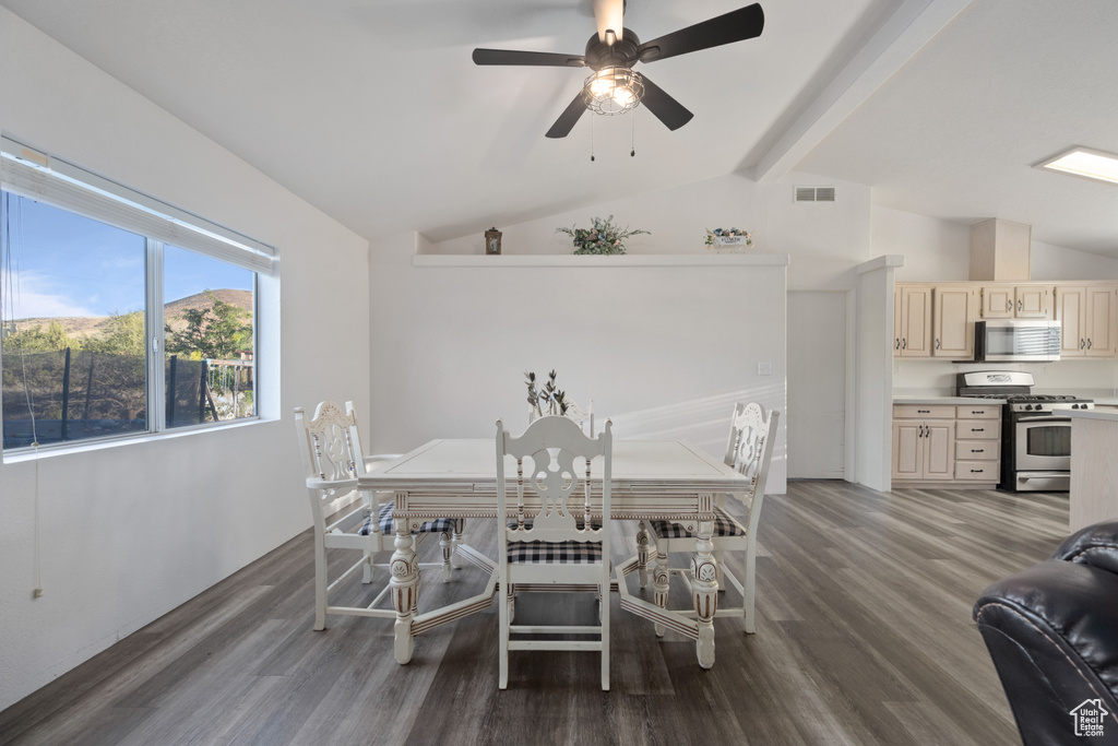 Dining space featuring ceiling fan, hardwood / wood-style flooring, and lofted ceiling with beams