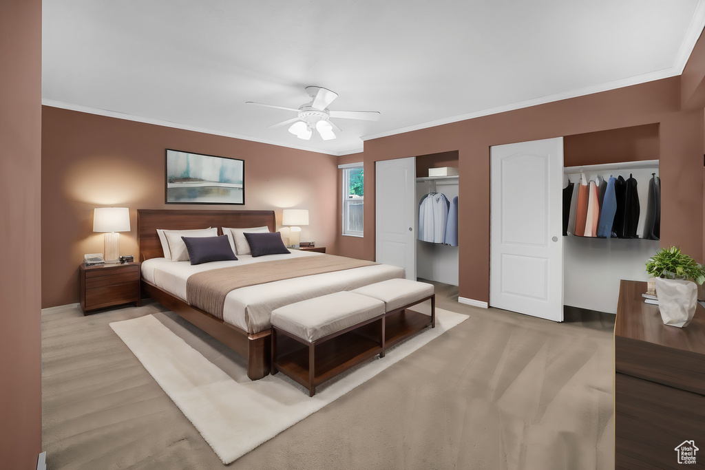 Bedroom with light wood-type flooring, crown molding, multiple closets, and ceiling fan