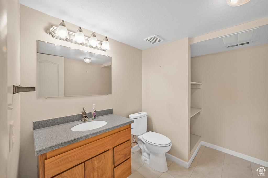 Bathroom with tile patterned flooring, toilet, and vanity