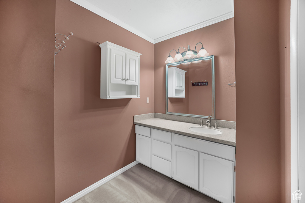 Bathroom featuring ornamental molding and vanity