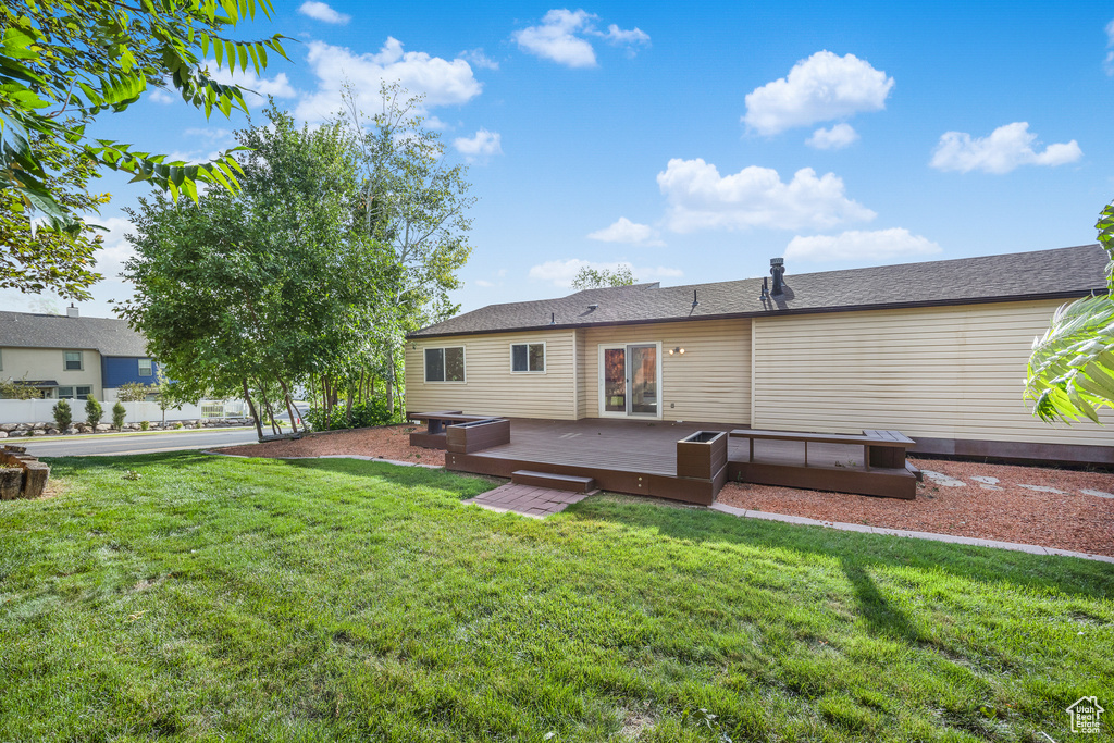 Rear view of property featuring a yard and a deck