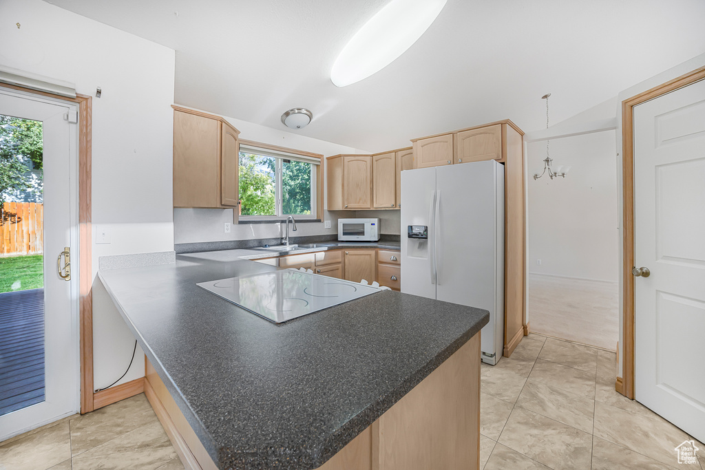 Kitchen featuring light brown cabinets, light tile patterned floors, sink, kitchen peninsula, and white appliances