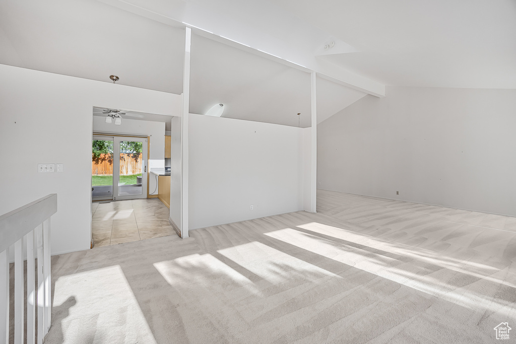 Interior space with beam ceiling, ceiling fan, high vaulted ceiling, and light carpet