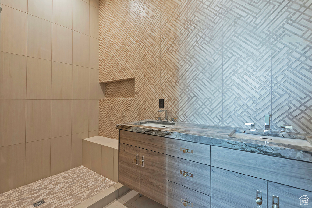 Bathroom featuring tile walls, vanity, and tasteful backsplash