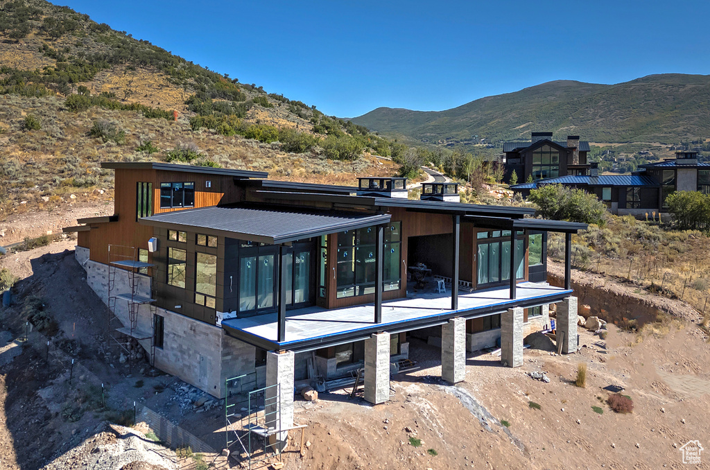 Rear view of property featuring a mountain view and a patio