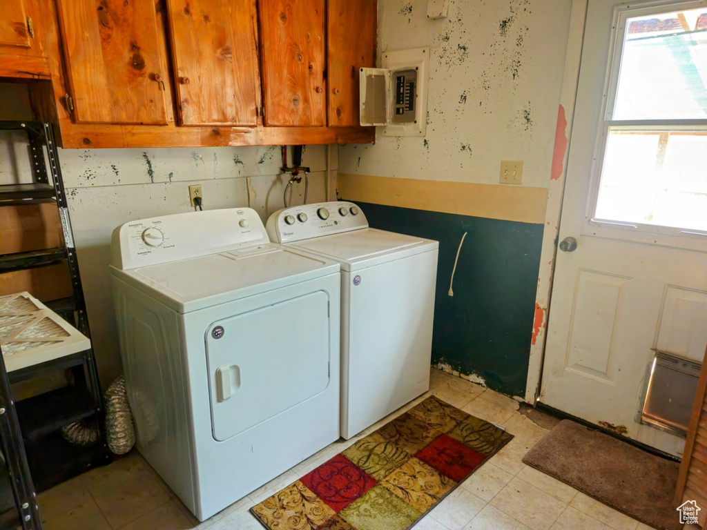 Laundry area with electric panel, washing machine and dryer, and cabinets