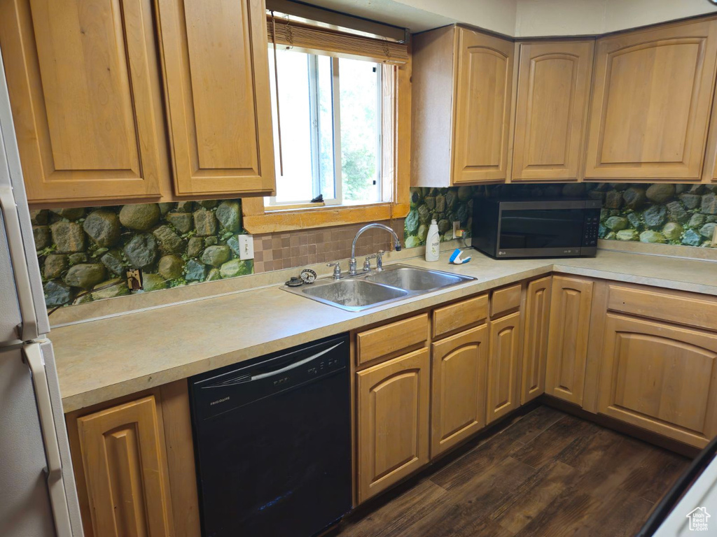 Kitchen with black dishwasher, decorative backsplash, dark hardwood / wood-style floors, and sink