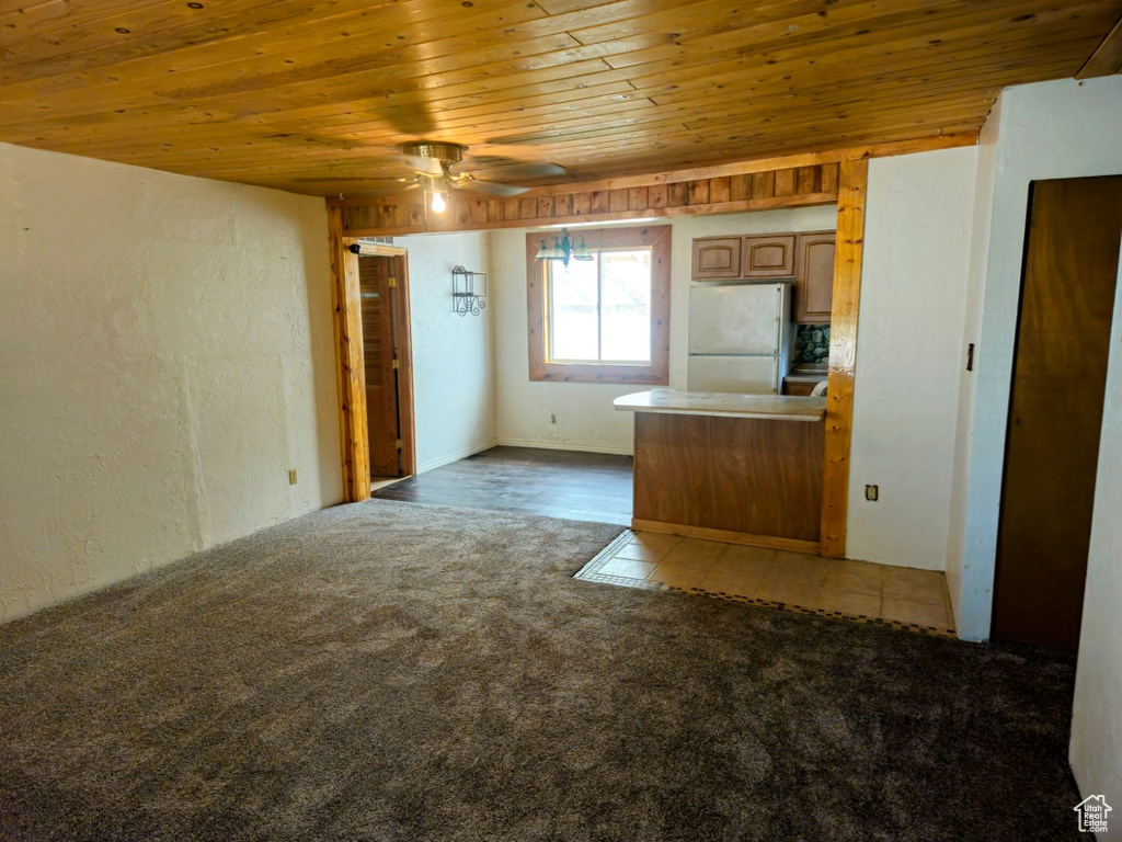 Kitchen with wooden ceiling, light colored carpet, ceiling fan, and white fridge