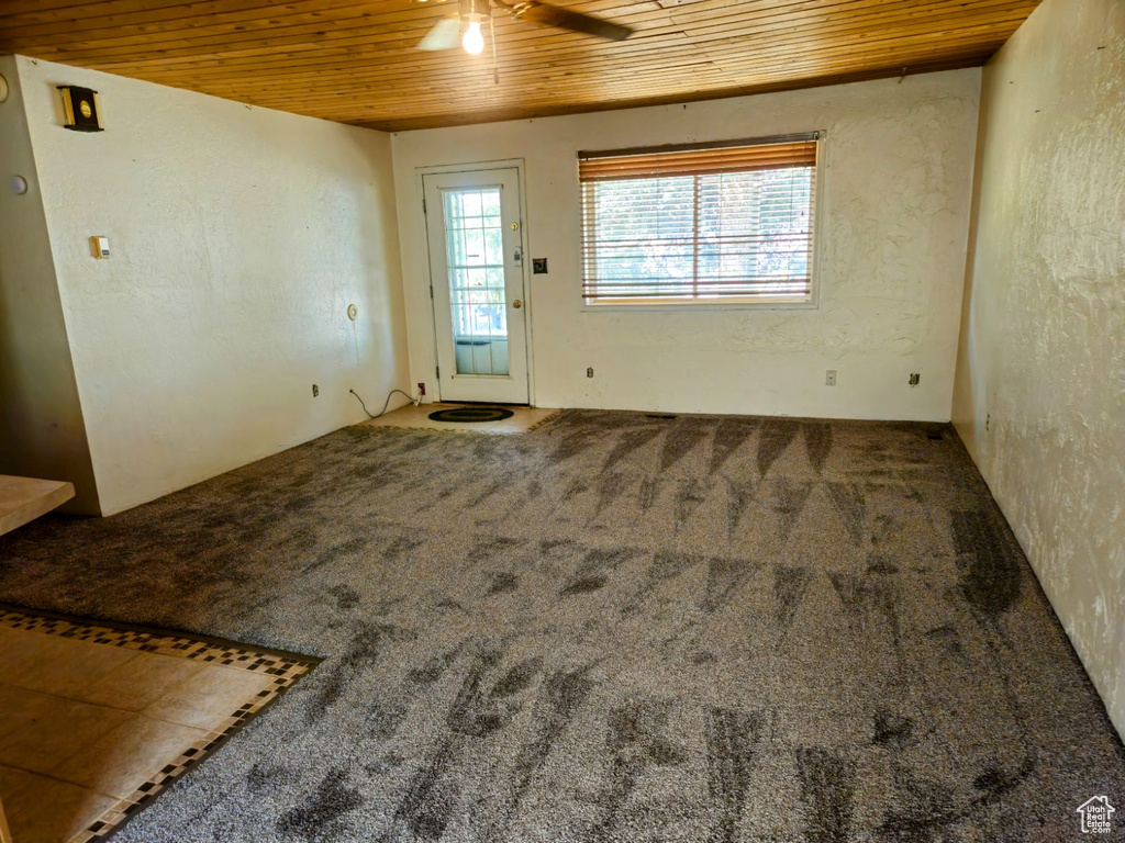 Carpeted entrance foyer featuring ceiling fan and wooden ceiling