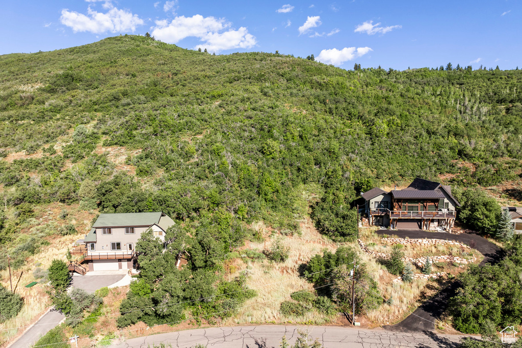 Aerial view of property and surrounding area with a forest