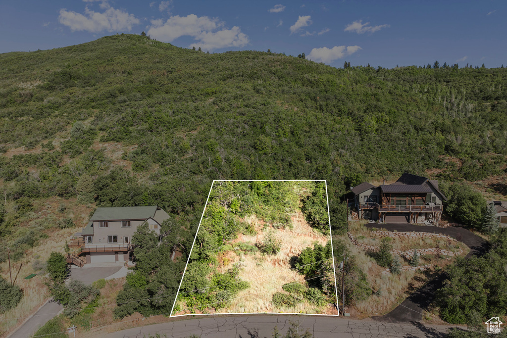 Aerial view of property and surrounding area featuring a forest and property parcel outlined
