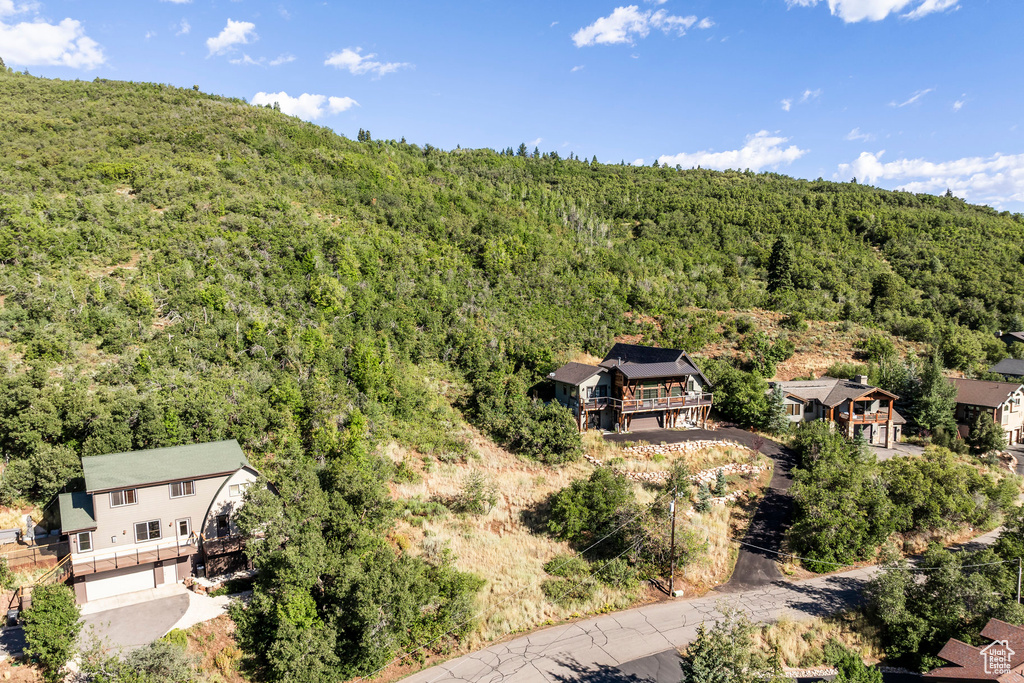 Aerial view of property and surrounding area featuring a heavily wooded area