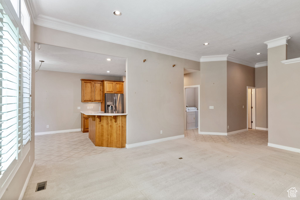 Unfurnished living room featuring crown molding and light colored carpet