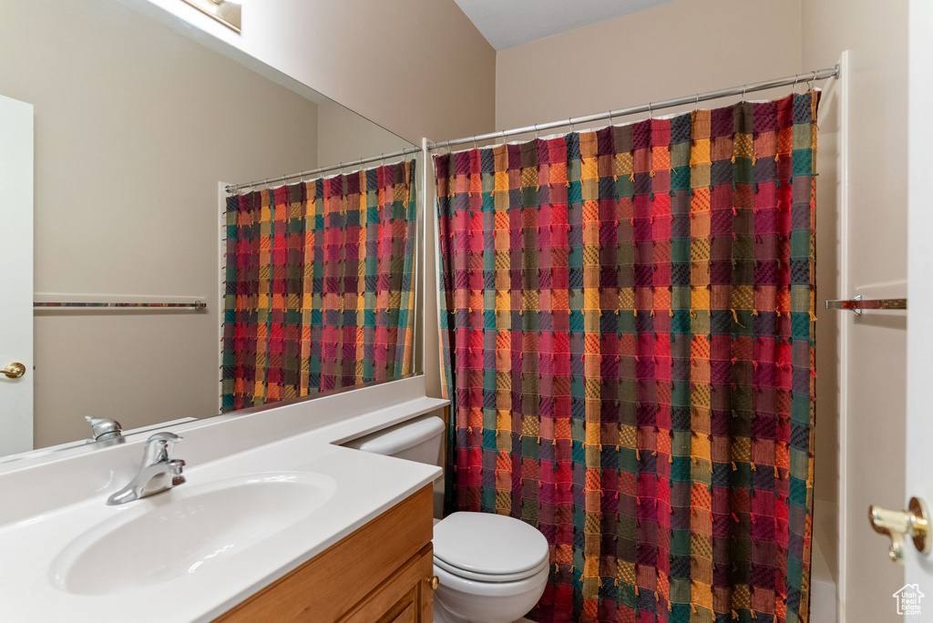 Full bathroom with vanity, toilet, and shower / bath combo with shower curtain