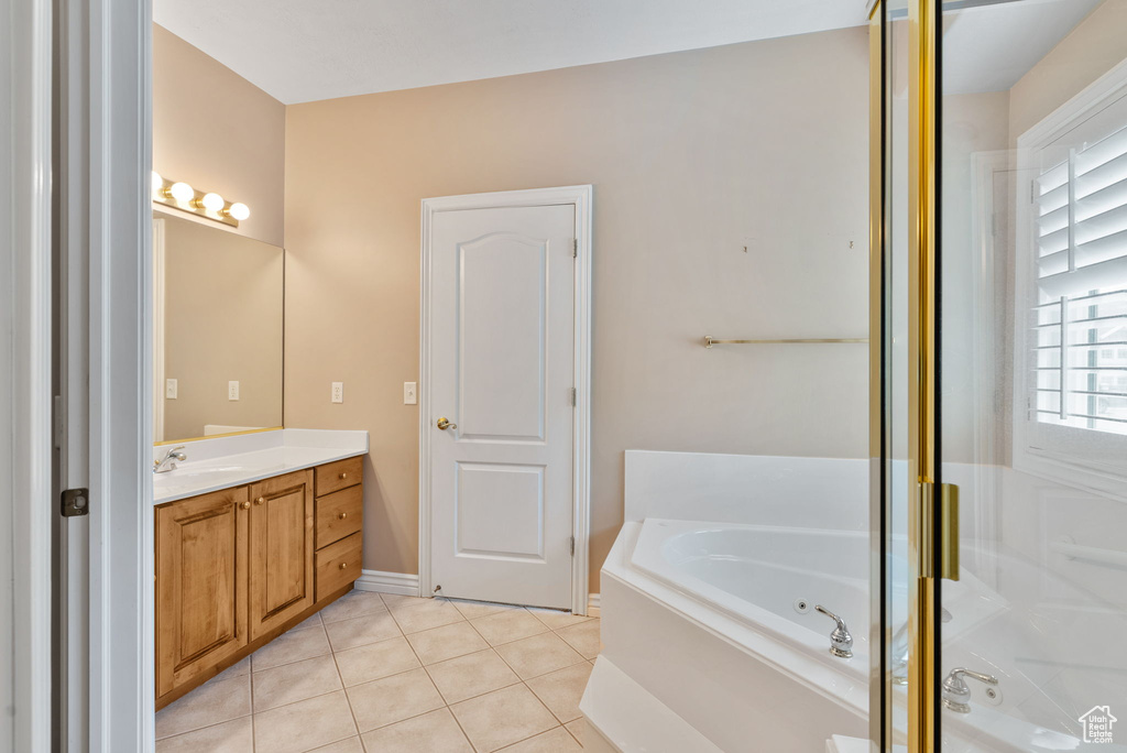 Bathroom featuring a tub, tile patterned floors, and vanity