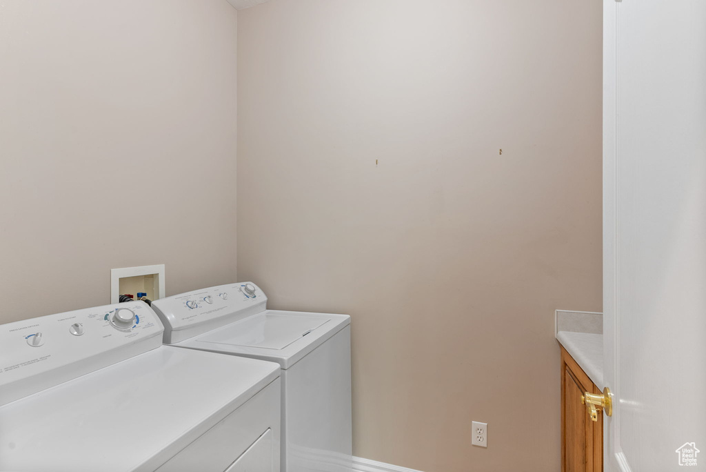 Clothes washing area with cabinets and washer and dryer