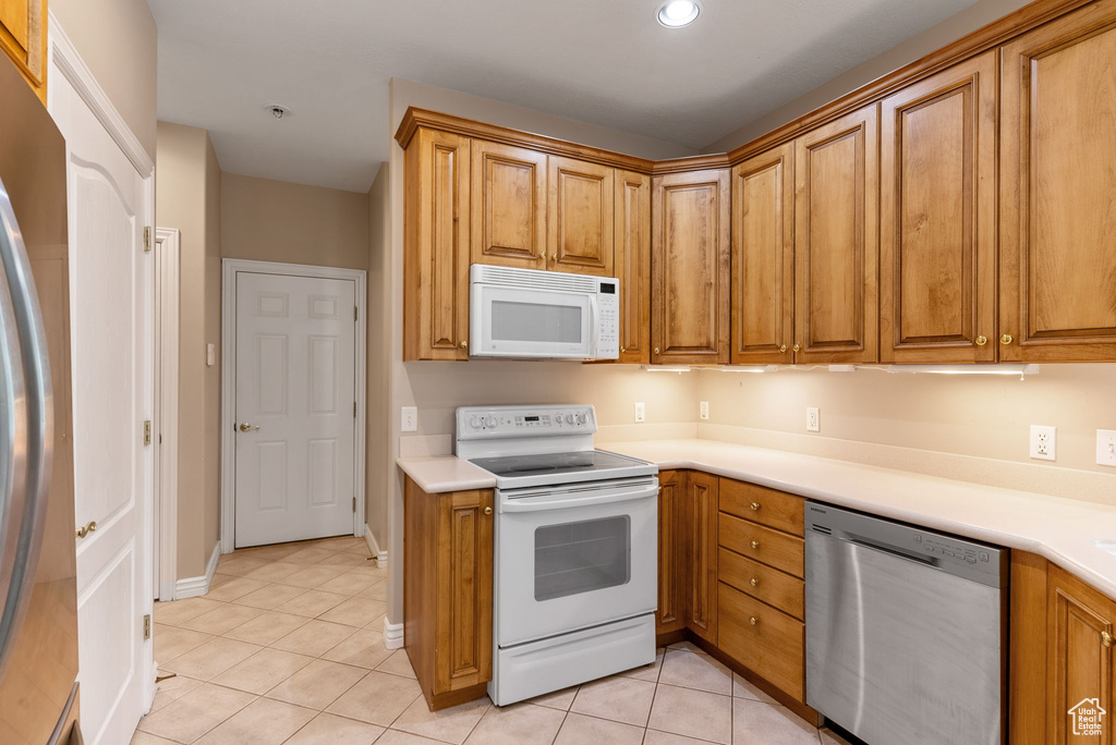 Kitchen with light tile patterned floors and stainless steel appliances