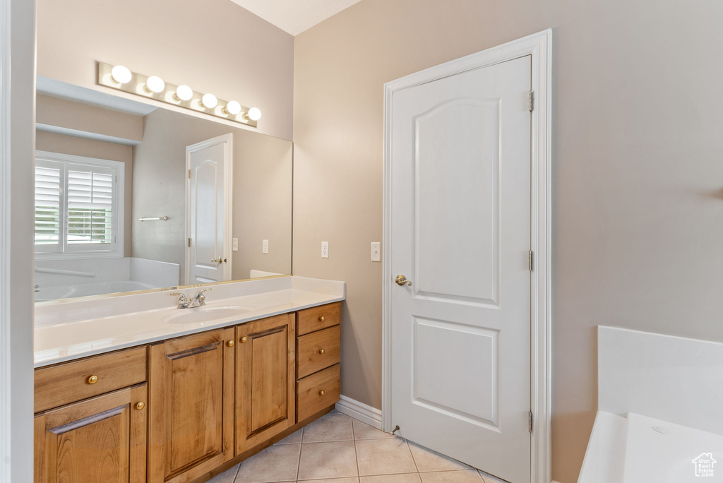 Bathroom featuring vanity, a tub, and tile patterned floors