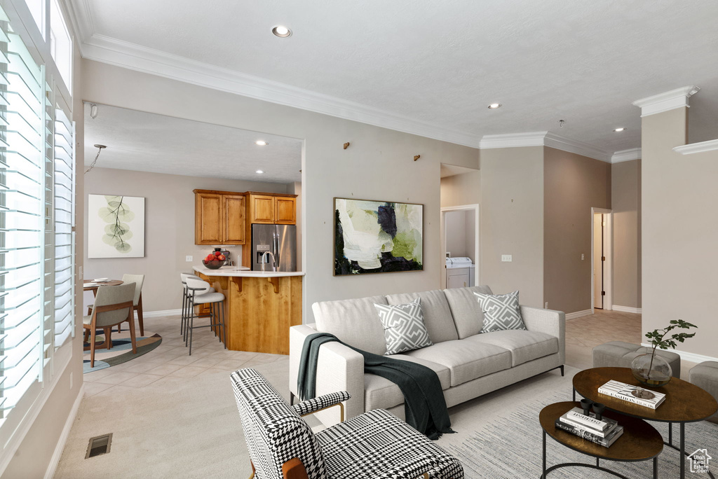 Carpeted living room featuring ornamental molding and washer / clothes dryer