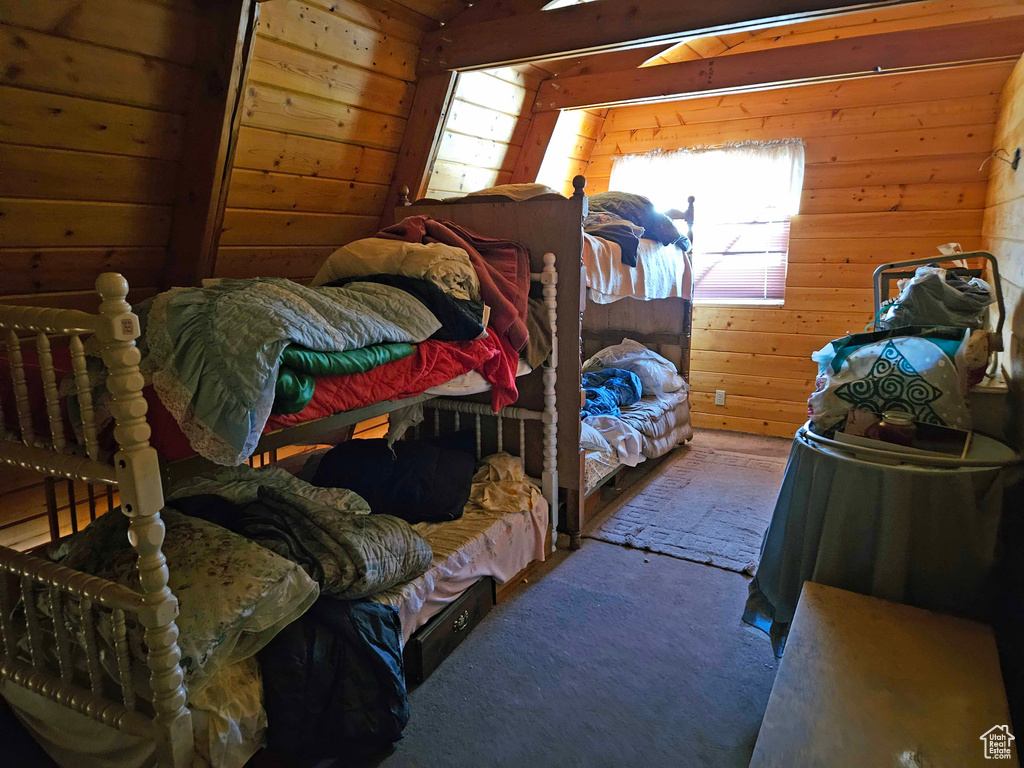 Bedroom with carpet flooring and wood walls