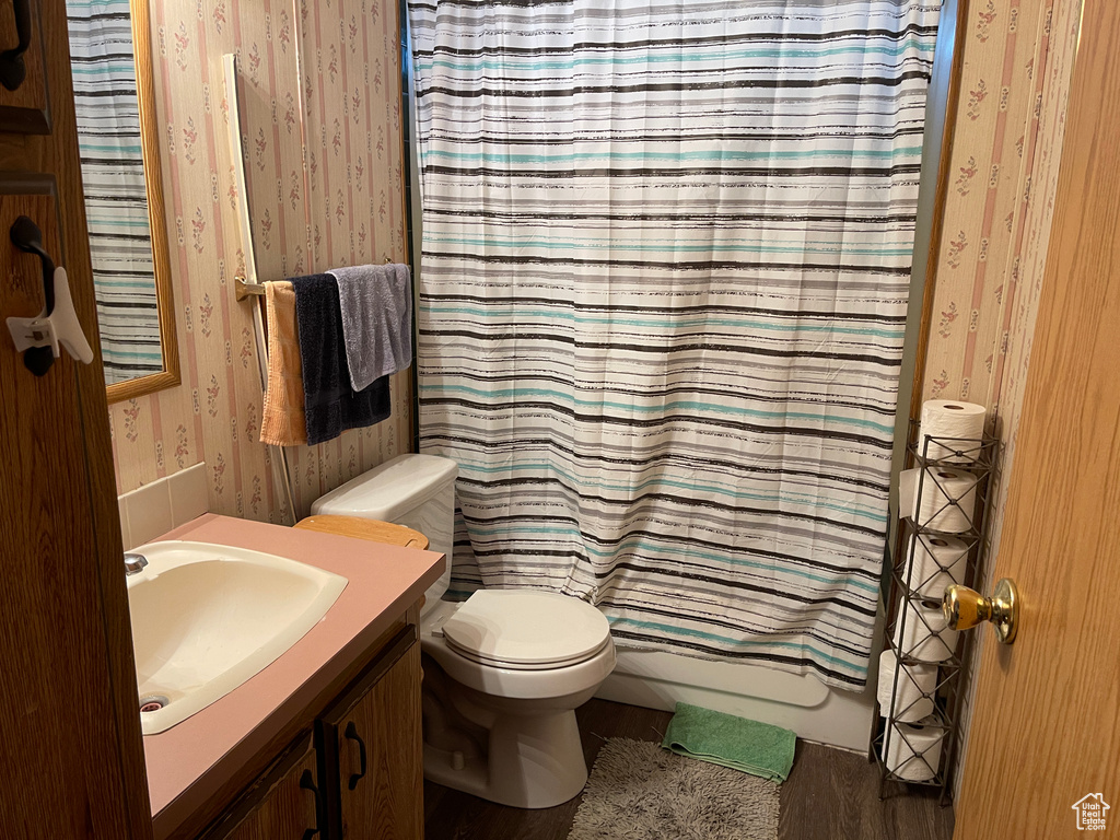 Full bathroom with shower / tub combo with curtain, toilet, and vanity