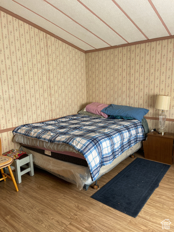 Bedroom featuring a textured ceiling and light hardwood / wood-style flooring