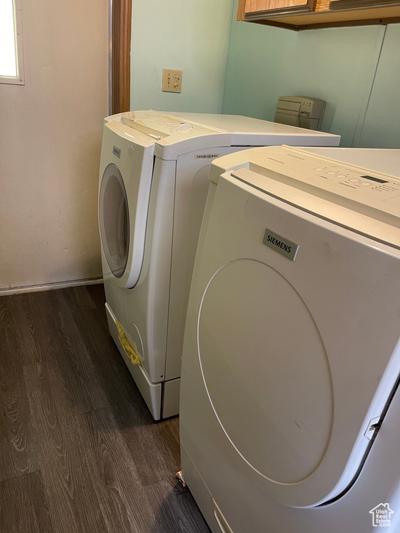 Laundry room with washing machine and dryer and dark wood-type flooring