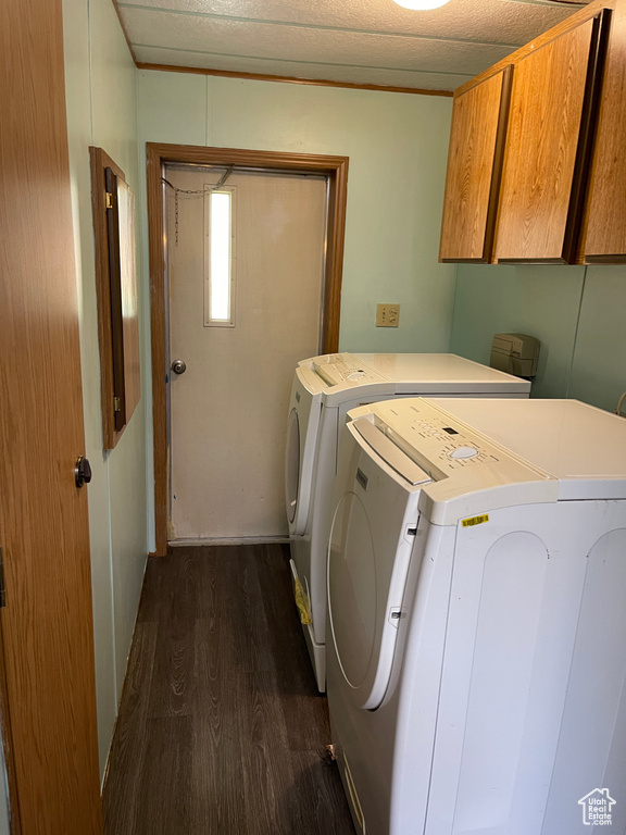 Washroom with washer and clothes dryer, dark hardwood / wood-style flooring, and cabinets