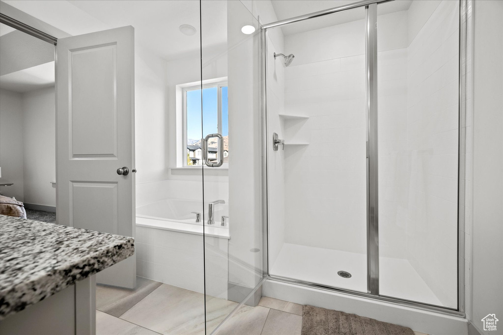 Bathroom featuring tile patterned floors and plus walk in shower
