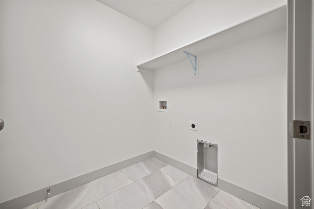 Laundry area featuring hookup for a washing machine, light tile patterned floors, and electric dryer hookup