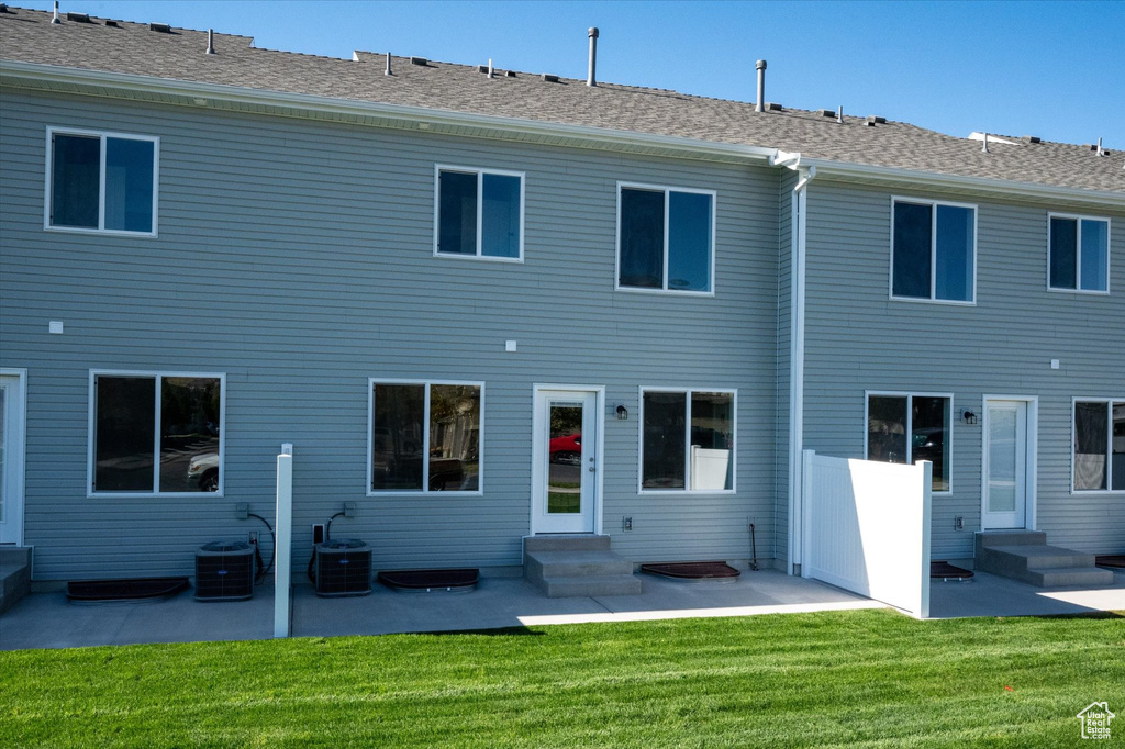 Back of property featuring cooling unit, a yard, and a patio area