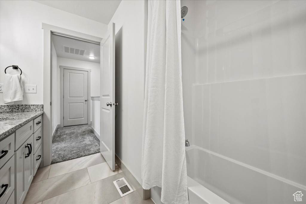 Bathroom featuring vanity, shower / bath combination with curtain, and tile patterned floors
