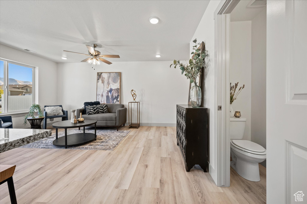 Living room with ceiling fan and light hardwood / wood-style flooring