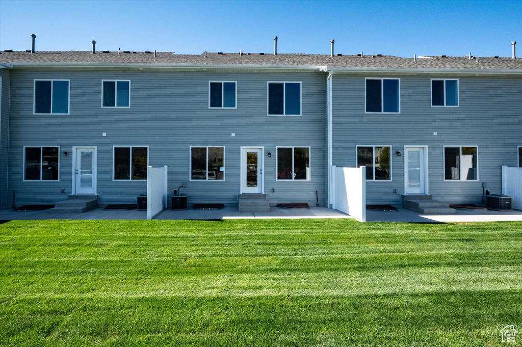 Back of house featuring a patio, a yard, and cooling unit