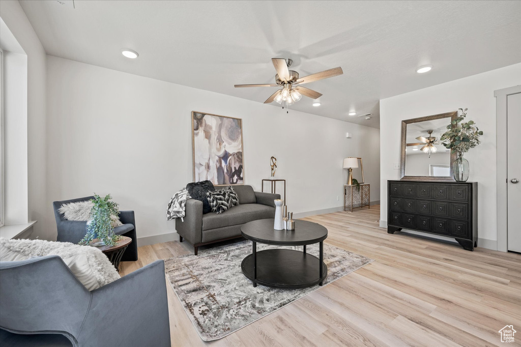 Living room with light hardwood / wood-style floors and ceiling fan