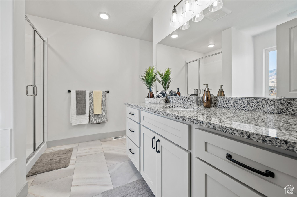 Bathroom with vanity, tile patterned floors, and a shower with shower door