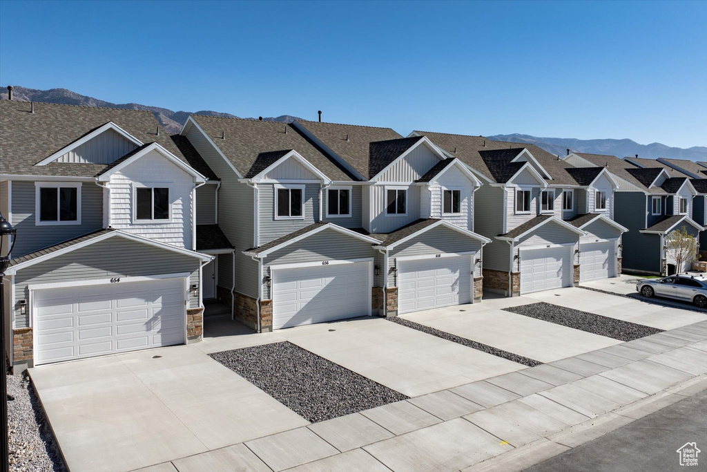 View of property with a garage and a mountain view