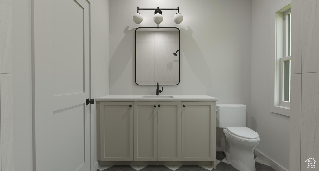 Bathroom featuring tile patterned flooring, toilet, and vanity